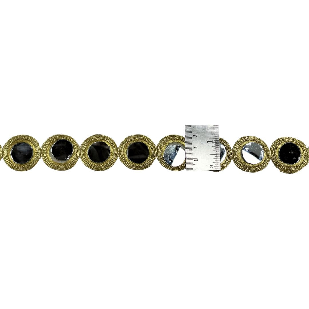 Decorative trim with circular patterns and a ruler for scale on a white background
